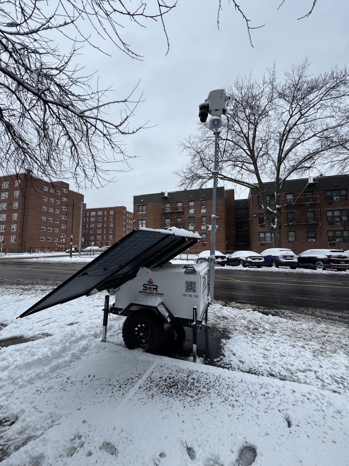 Mobile surveillance tower watching a snowy residential street in winter
